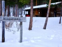 a sign in the snow near a cabin