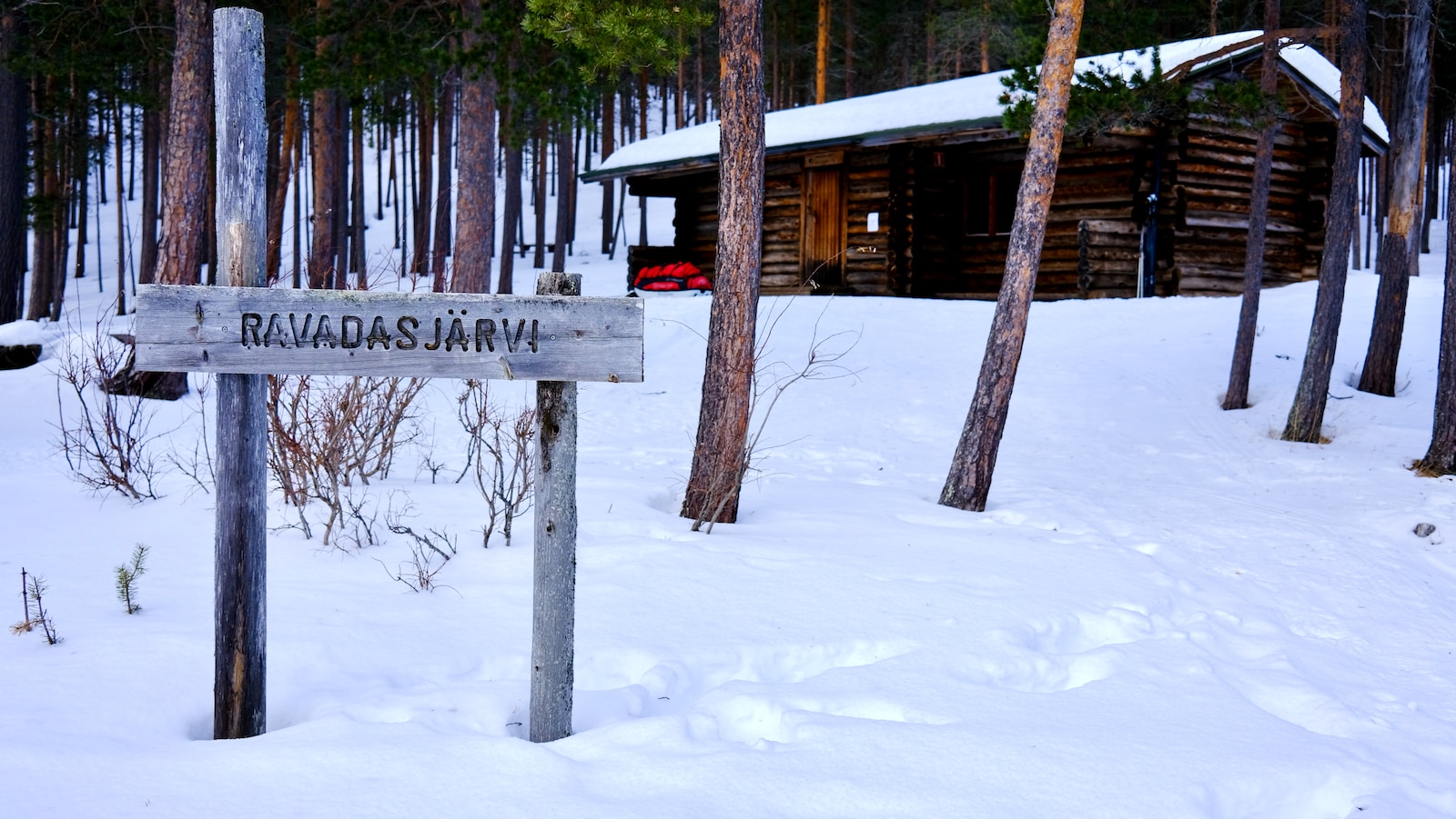 a sign in the snow near a cabin