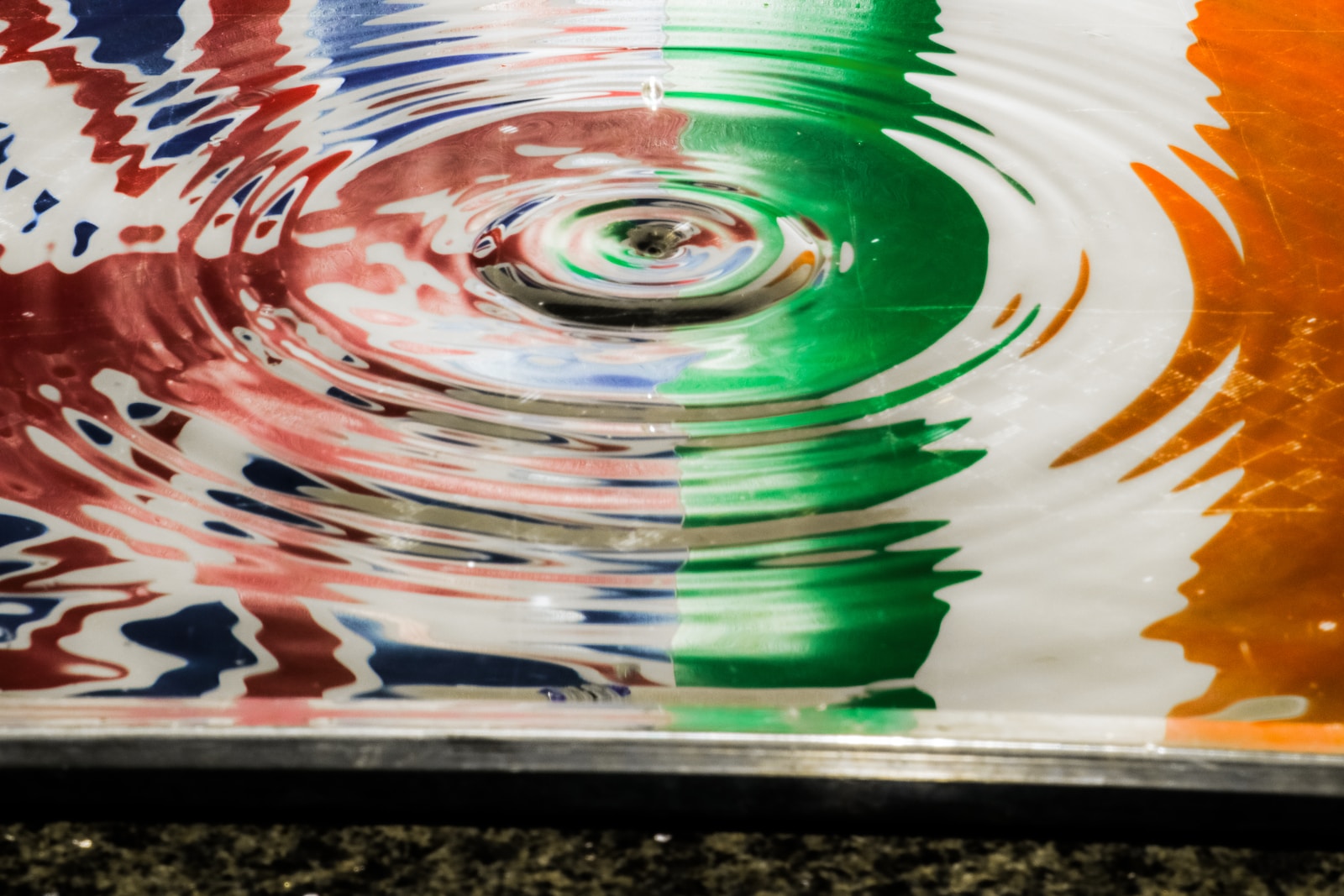 a multicolored bowl with water ripples into it