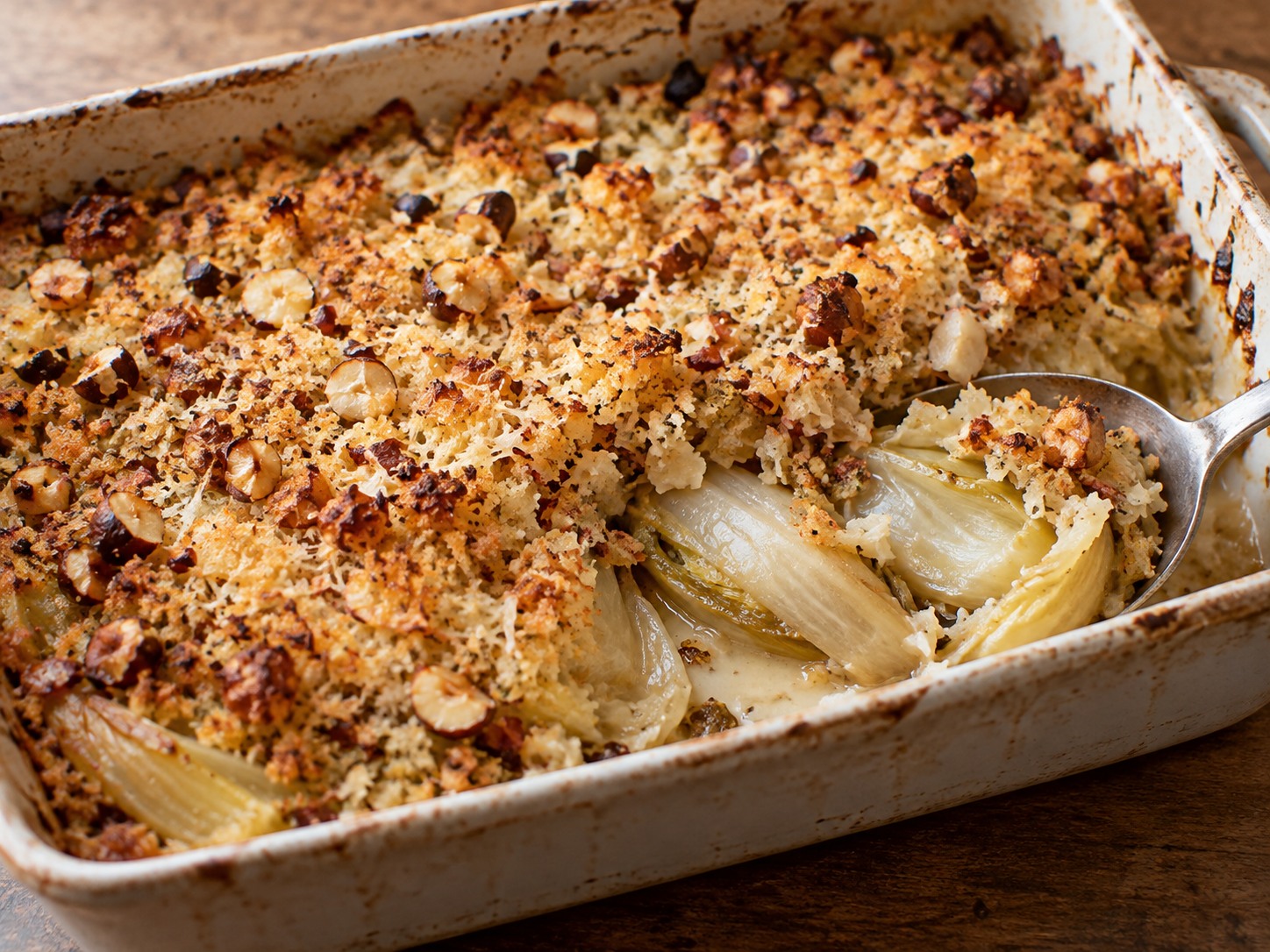 Crumble salé doré aux noisettes et au parmesan sur une garniture d’endives cuites