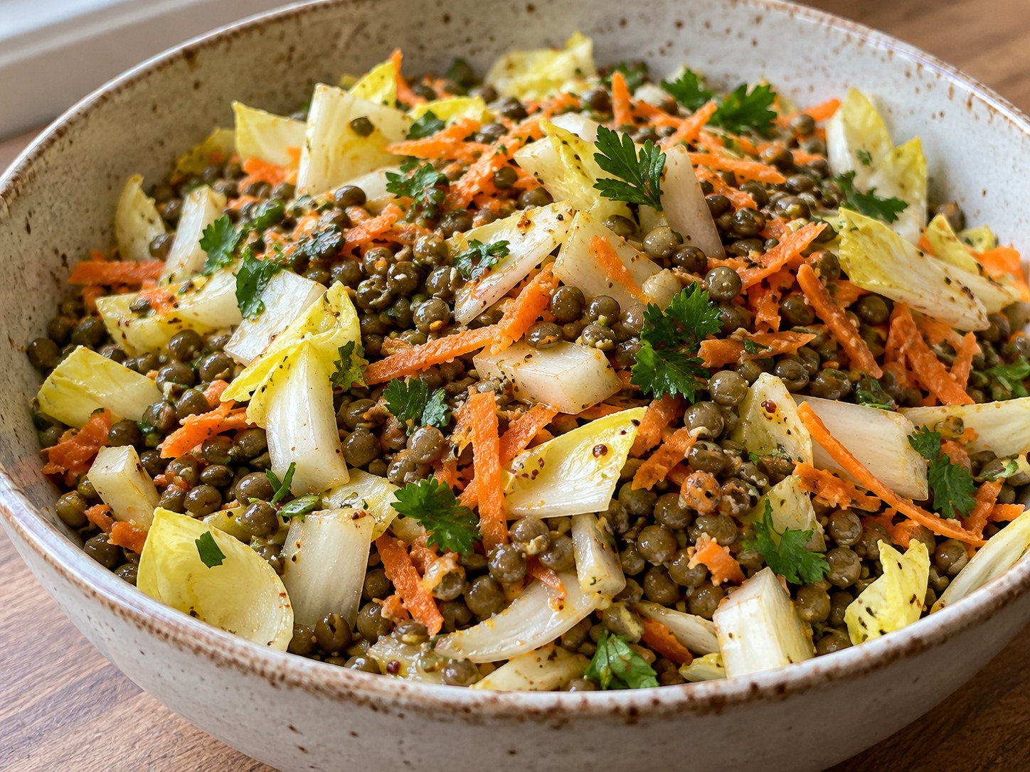 Salade de lentilles vertes avec morceaux d’endives crues, carotte râpée et persil
