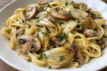 Tagliatelles enrobées de crème avec champignons dorés, lanières d’endives et persil